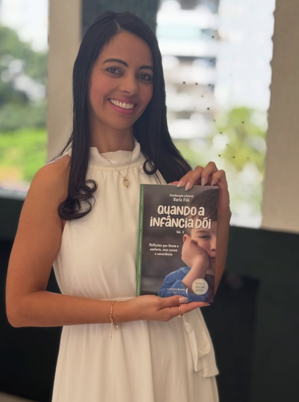 Tia Laura segurando o livro Quando a Infância Dói Volume 3